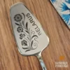 Гребень с гравировкой "BELARUS" и цветочным узором, изготовленный из металла.